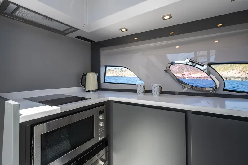 Polar Yacht Photos Pics Modern kitchen interior of 2023 Pershing 5x yacht with sleek appliances and ocean view.