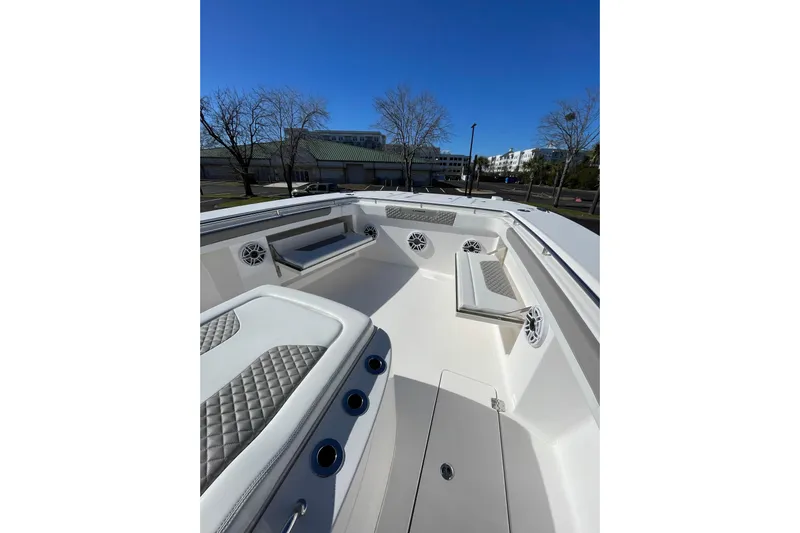  Yacht Photos Pics 2024 Caymas 34 CT boat interior with cushioned seating and speakers under clear blue sky.