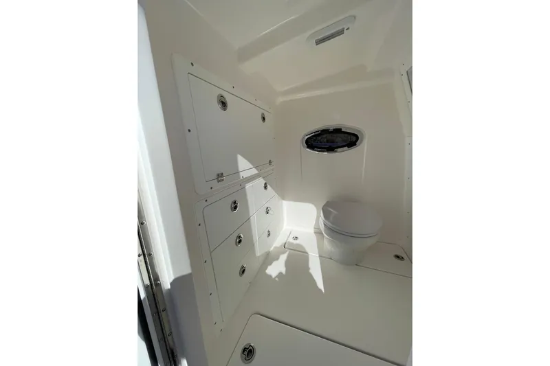  Yacht Photos Pics 2024 Caymas 34 CT boat interior bathroom with storage cabinets and toilet.