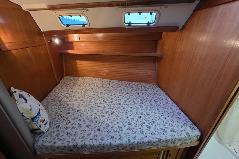 Moana Yacht Photos Pics Cozy cabin interior of 1998 Catalina 42 MkII sailboat with wooden finish and floral bedding.