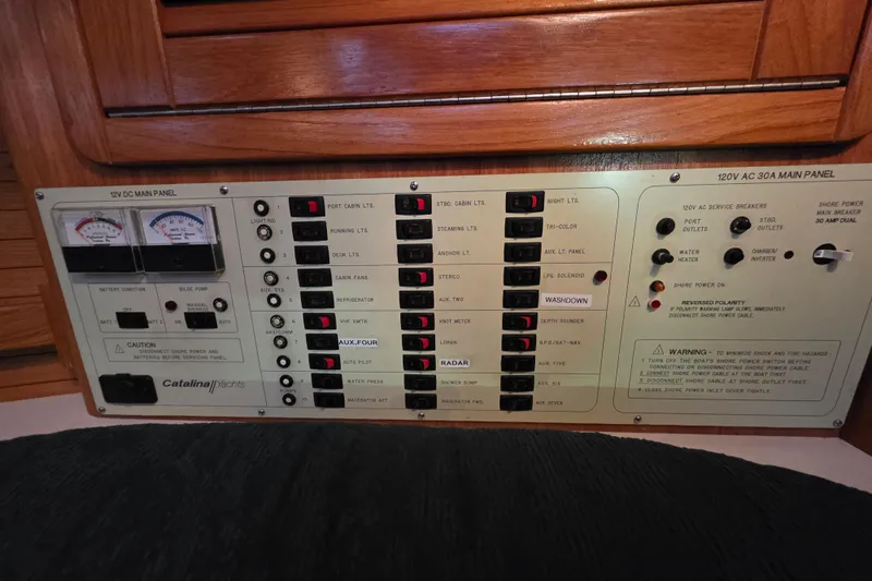 Moana Yacht Photos Pics Electrical control panel of a 1998 Catalina 42 MkII yacht, featuring various switches and gauges.