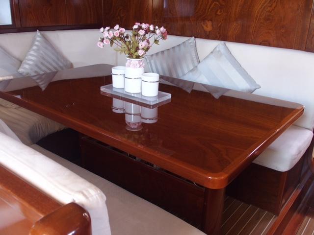 Luxurious Amel 54 yacht interior with elegant wooden table and plush seating, 2010 model.