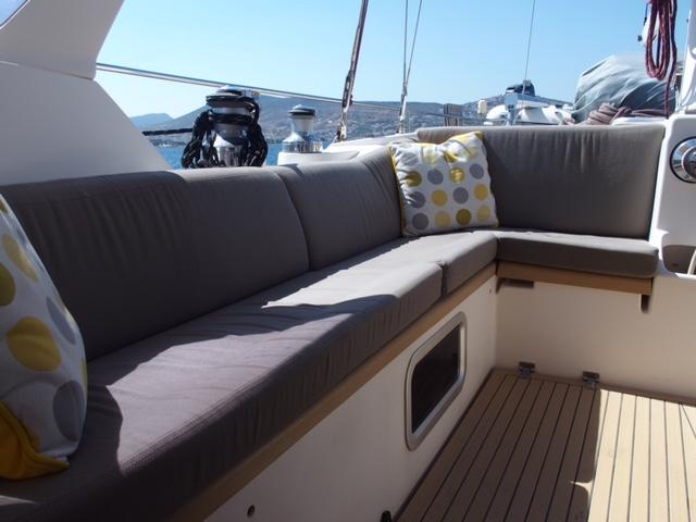 Amel 54 yacht cockpit with cushioned seating, 2010 model, featuring polka dot pillows.