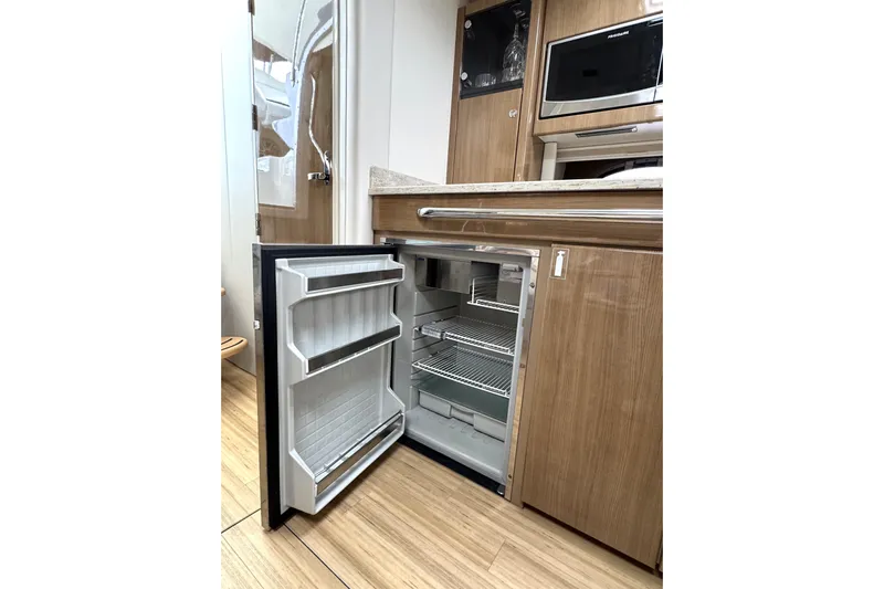 Blue Skye Yacht Photos Pics 2016 Formula 34 Performance Cruiser interior with open fridge and wooden cabinetry.