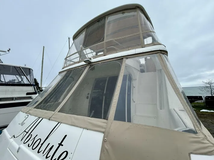  Yacht Photos Pics 2001 Silverton 410 Sport Bridge yacht with enclosed upper deck, docked on a cloudy day.