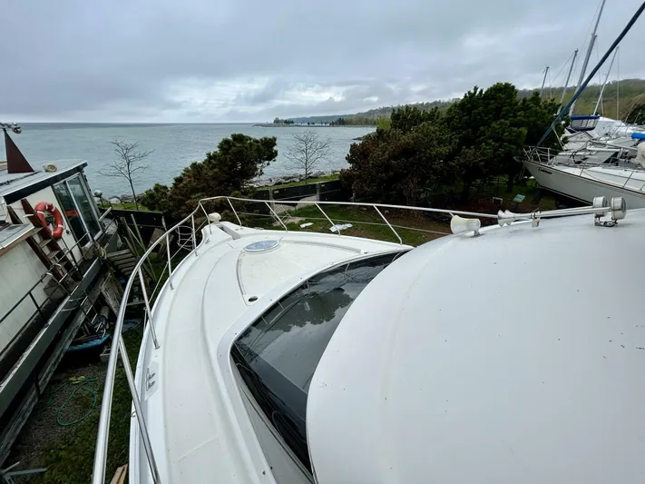  Yacht Photos Pics 2001 Silverton 410 Sport Bridge yacht docked by a scenic lakeside.