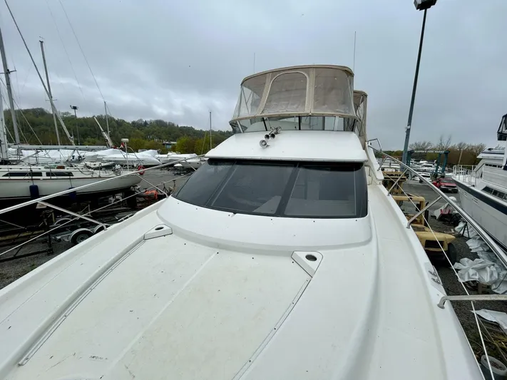  Yacht Photos Pics 2001 Silverton 410 Sport Bridge yacht docked in a marina on a cloudy day.