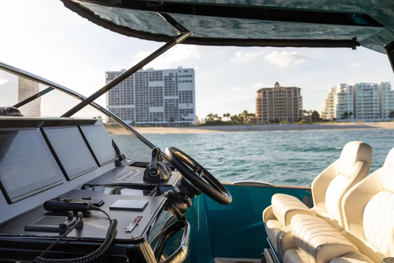  Yacht Photos Pics 2024 Solaris Power 52 Open yacht interior with ocean and cityscape view.