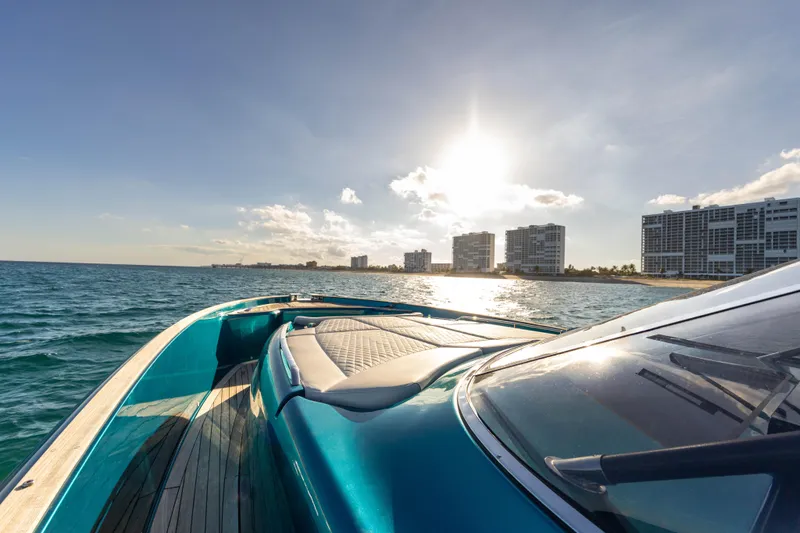  Yacht Photos Pics 2024 Solaris Power 52 Open yacht cruising near coastal city skyline at sunset.