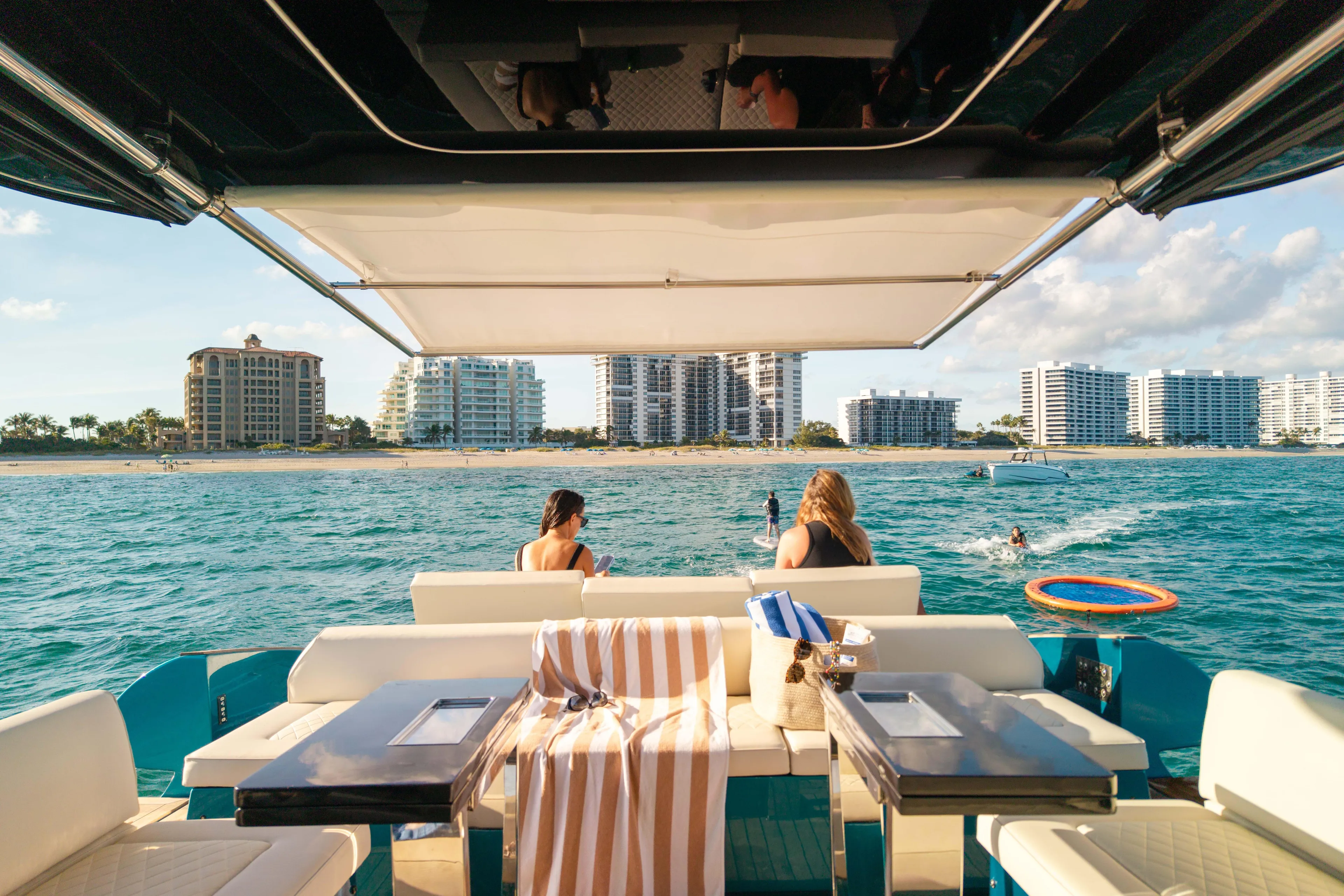  Yacht Photos Pics 2024 Solaris Power 52 Open yacht with beach view, people relaxing onboard.