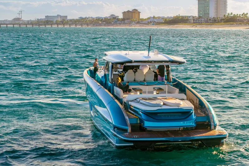  Yacht Photos Pics 2024 Solaris Power 52 Open yacht cruising near a coastal cityscape.
