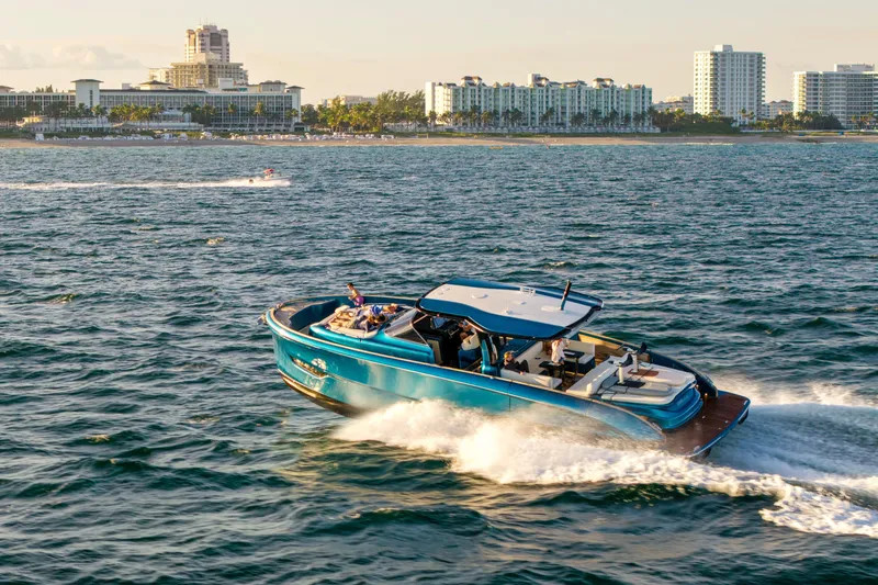  Yacht Photos Pics 2024 Solaris Power 52 Open yacht cruising near a coastal city skyline.