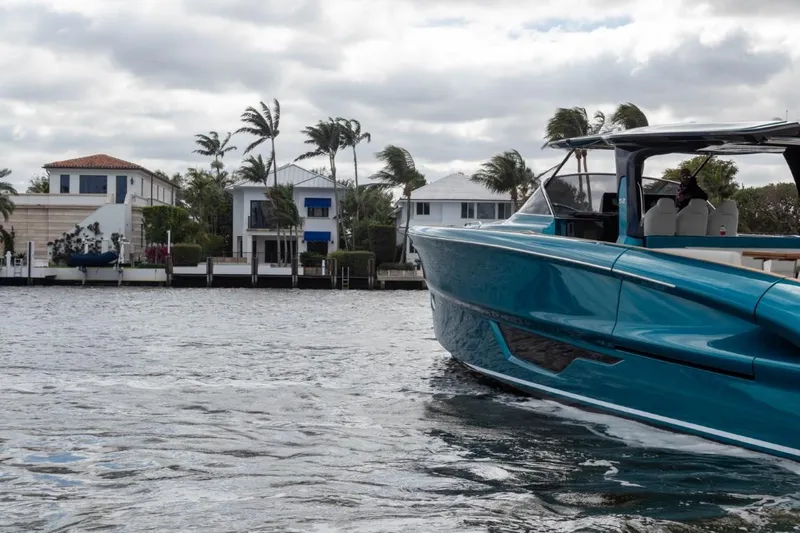  Yacht Photos Pics 2024 Solaris Power 52 Open yacht cruising near waterfront homes.