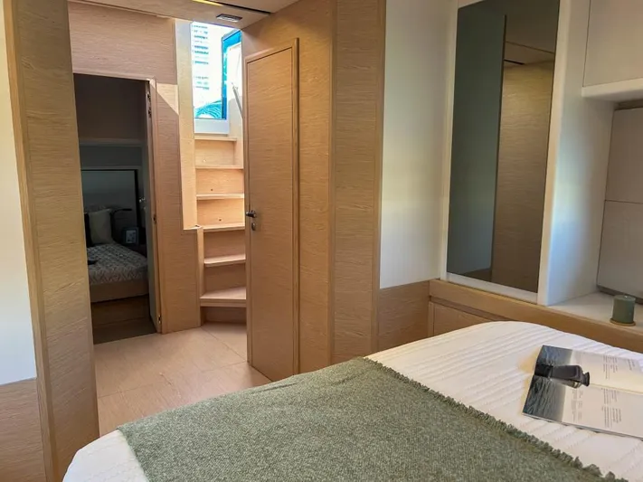  Yacht Photos Pics Interior cabin of 2024 Solaris Power 52 Open yacht with wooden finishes and cozy bedding.