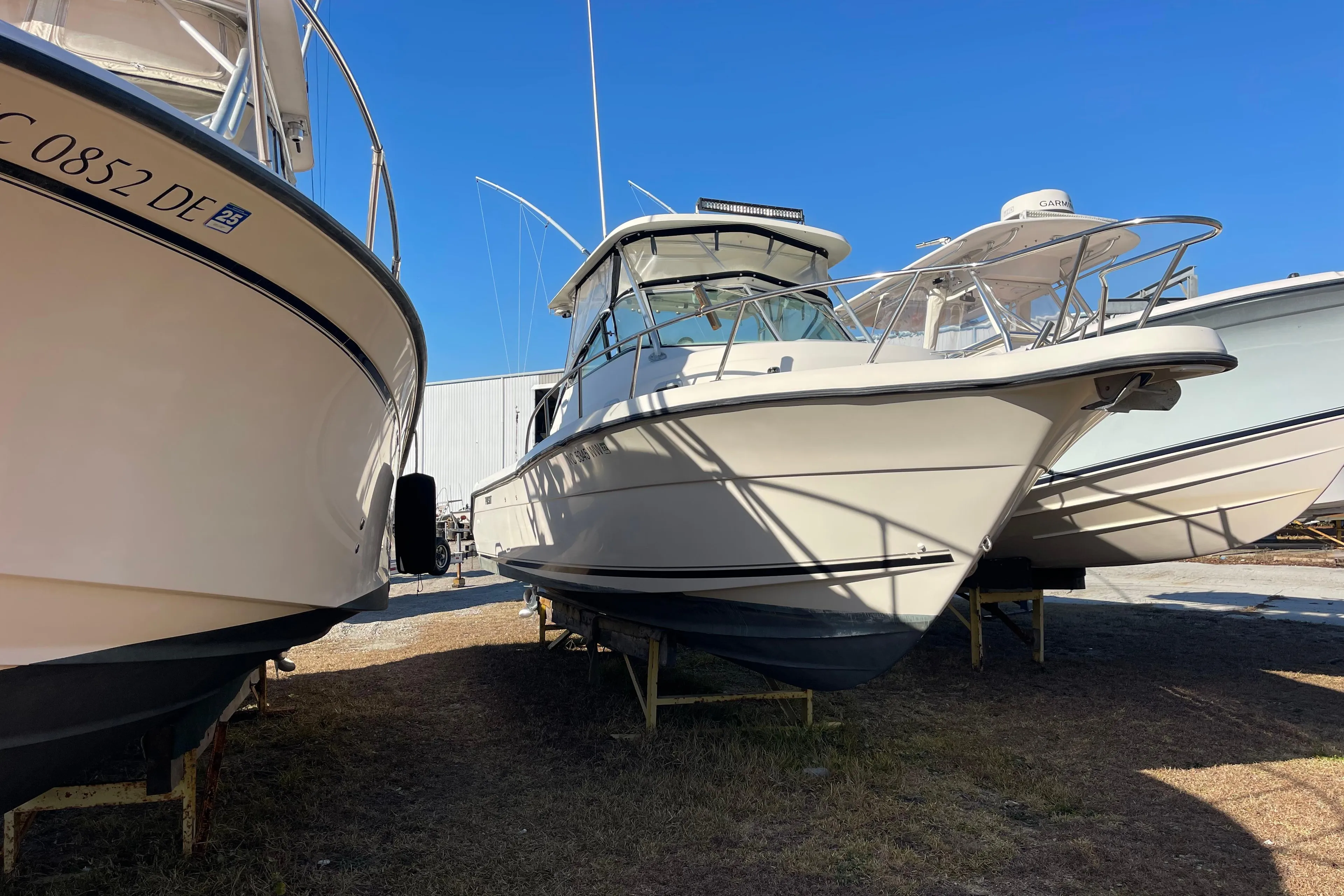 2003 Pursuit 2870 Walkaround boat on display in a marina, surrounded by other vessels.