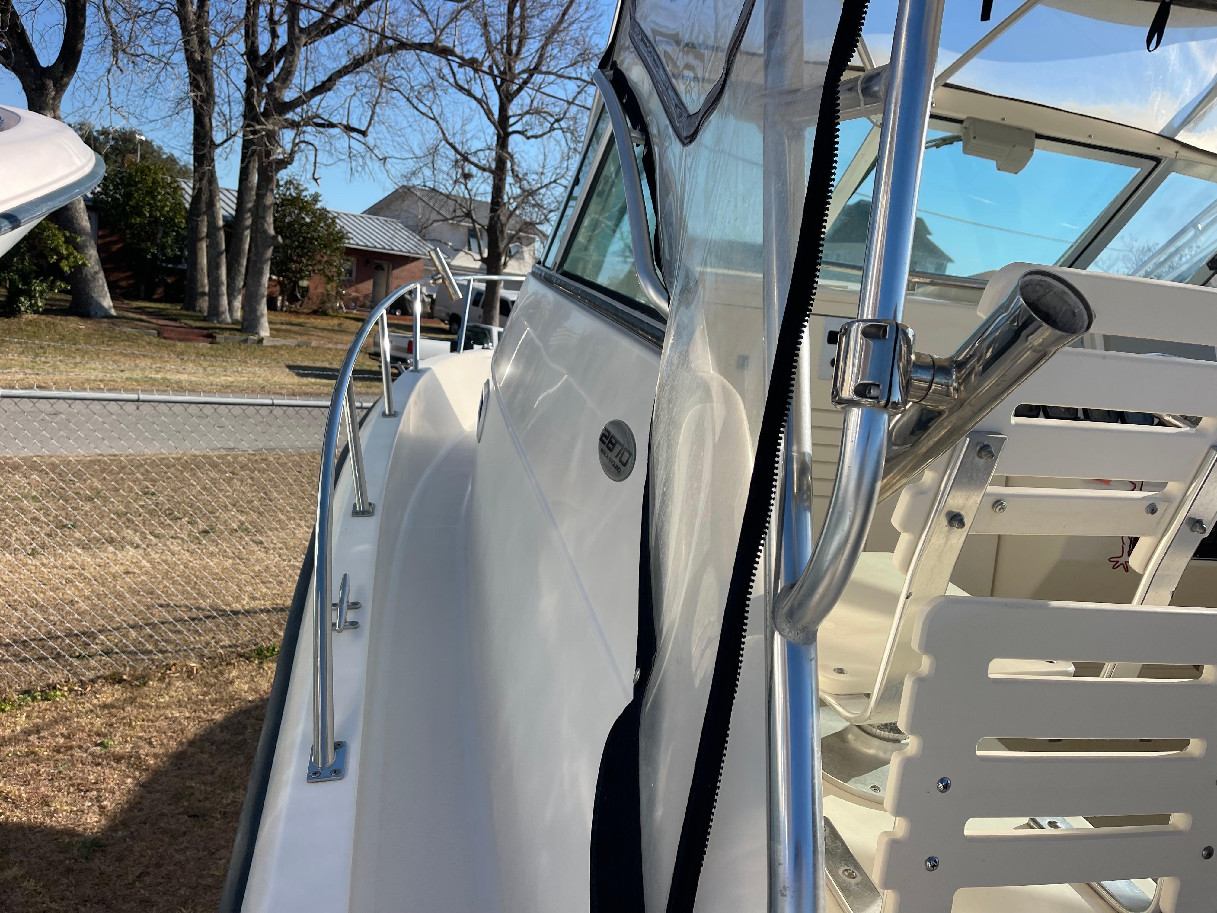 2003 Pursuit 2870 Walkaround boat, side view with railing and clear canopy.