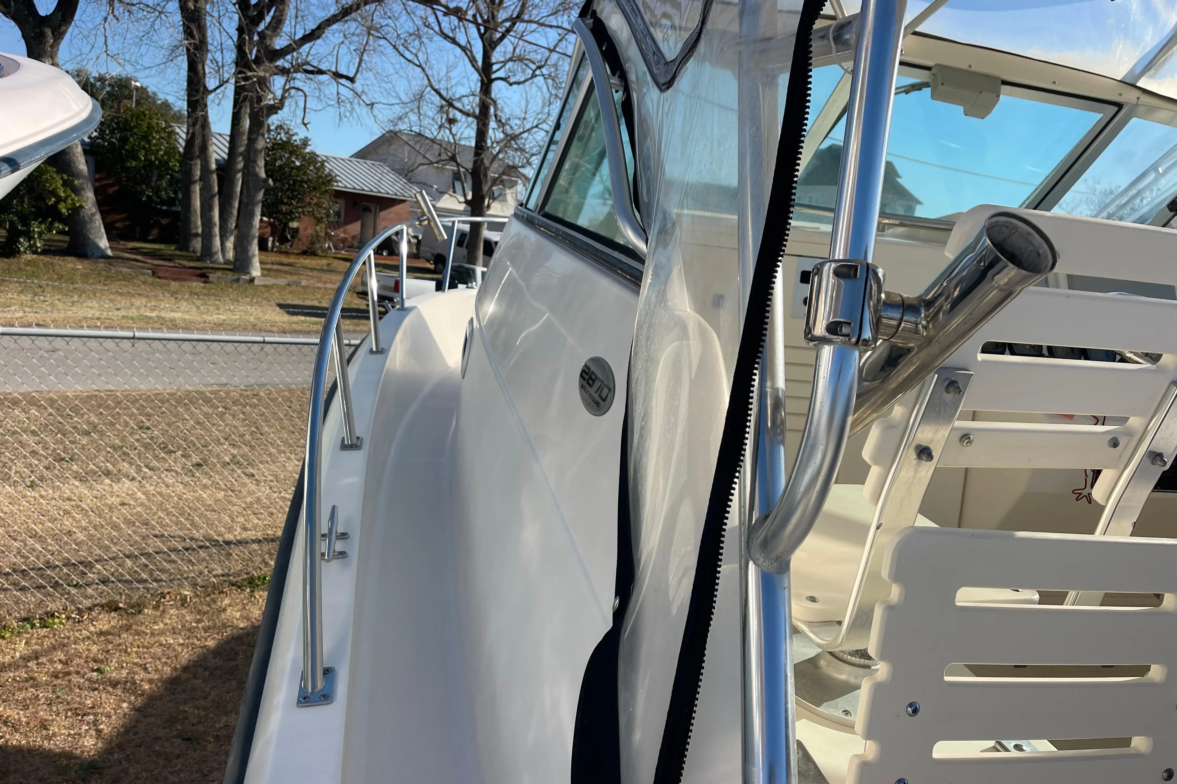 2003 Pursuit 2870 Walkaround boat, side view with railing and clear canopy.