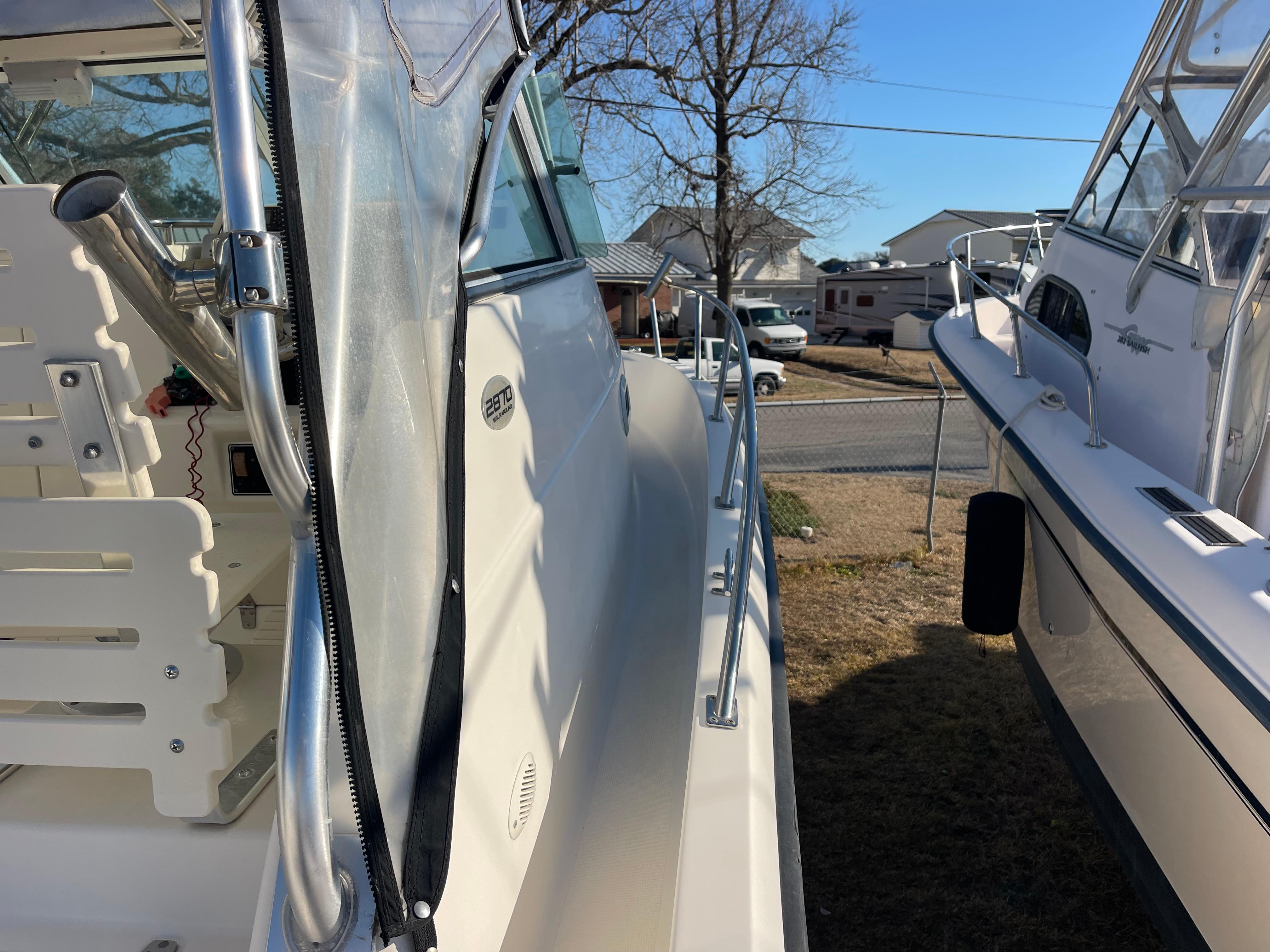 2003 Pursuit 2870 Walkaround boat, side view, parked outdoors on a sunny day.