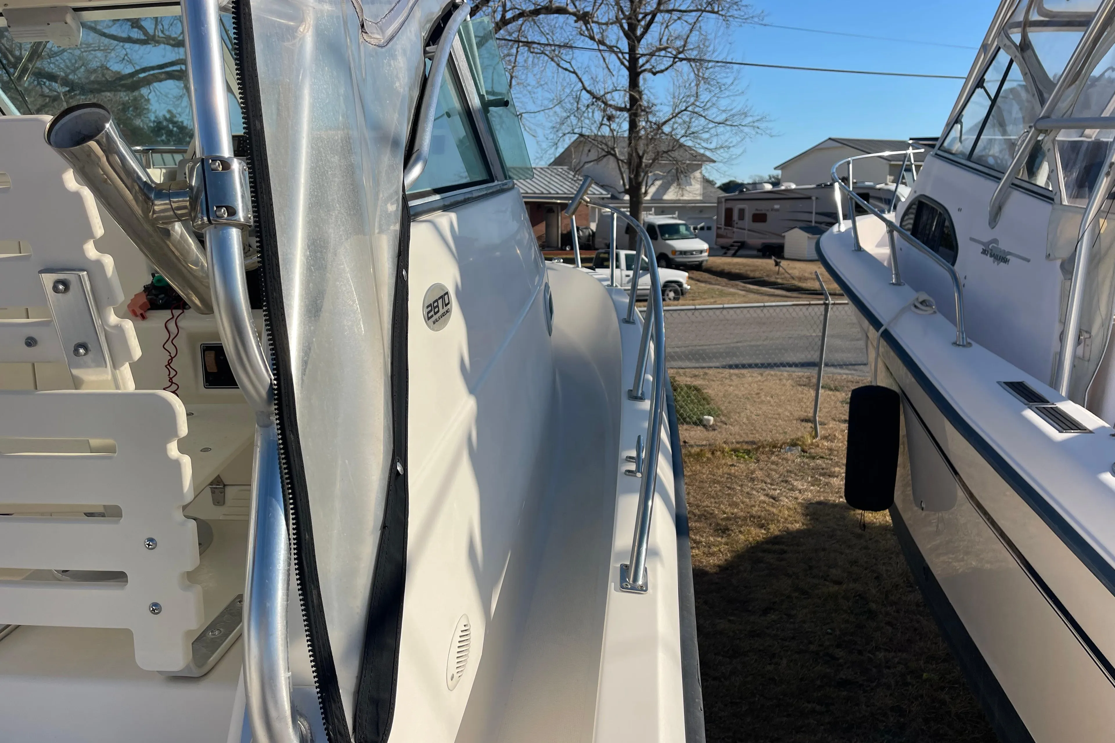 2003 Pursuit 2870 Walkaround boat, side view, parked outdoors on a sunny day.