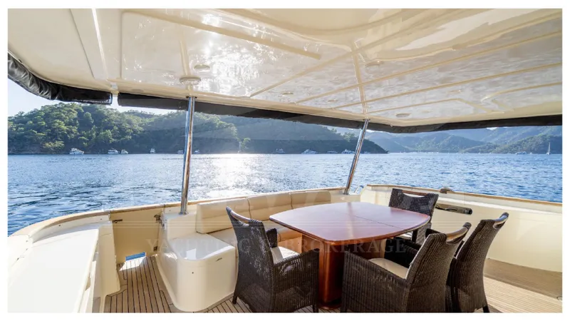  Yacht Photos Pics Outdoor dining area on 2008 Ferretti Yachts Customline Navetta 26, overlooking serene waters.