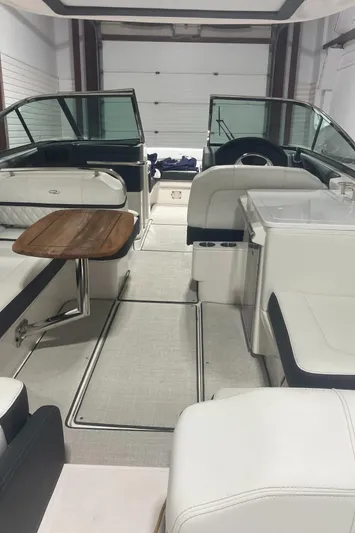  Yacht Photos Pics 2024 Regal 29 OBX boat interior with seating and wooden table.