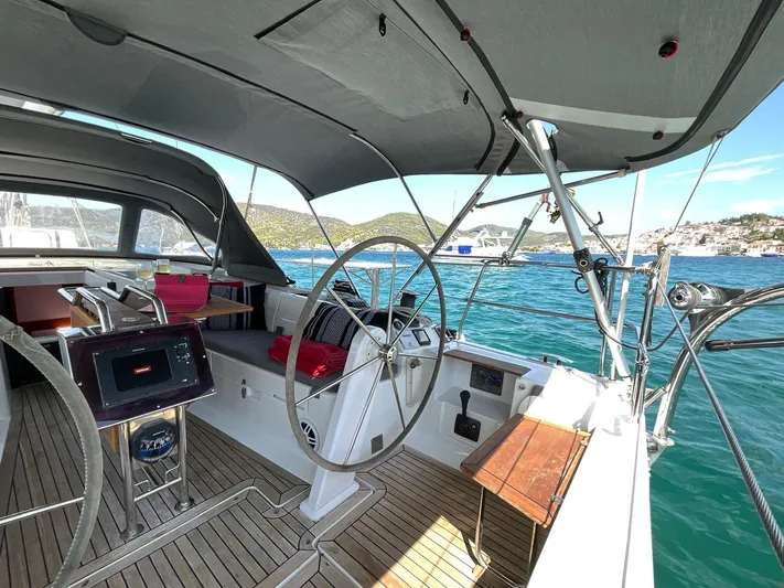 Starla Yacht Photos Pics 2012 Hanse 445 yacht cockpit with steering wheel, teak flooring, and scenic ocean view.