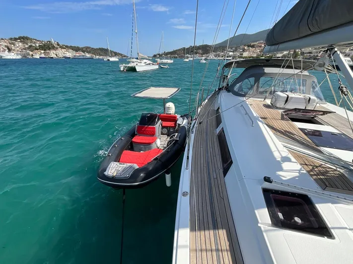 Starla Yacht Photos Pics Sailing yacht Hanse 445 (2012) moored in turquoise waters with a small dinghy alongside.