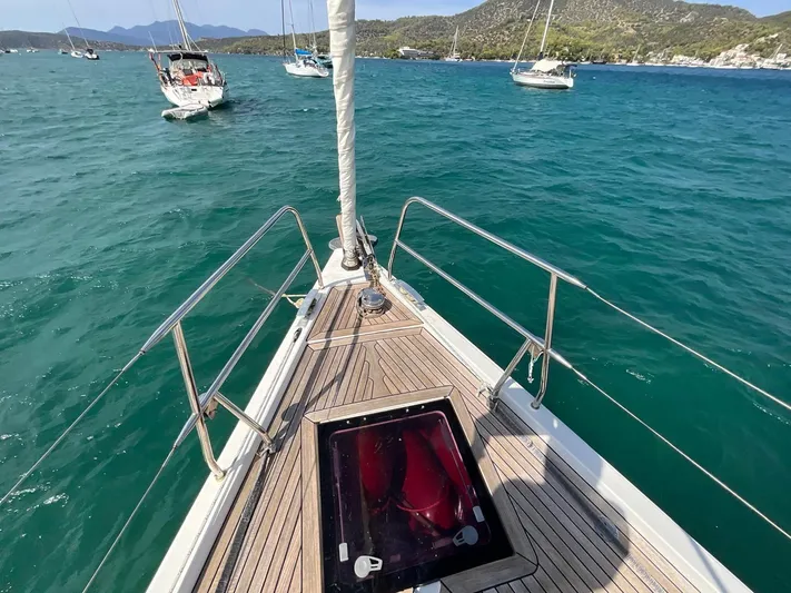 Starla Yacht Photos Pics Bow of 2012 Hanse 445 sailboat on turquoise water with distant sailboats.