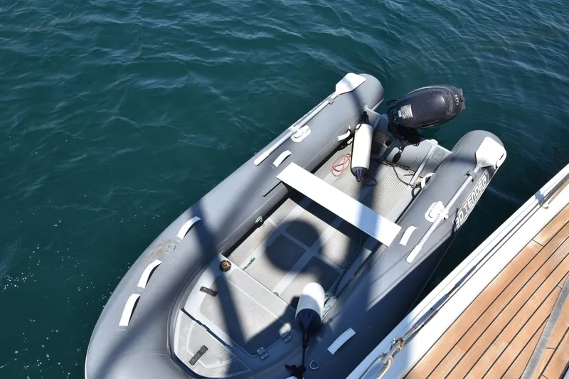 Starla Yacht Photos Pics Inflatable dinghy with motor beside a 2012 Hanse 445 yacht on calm water.