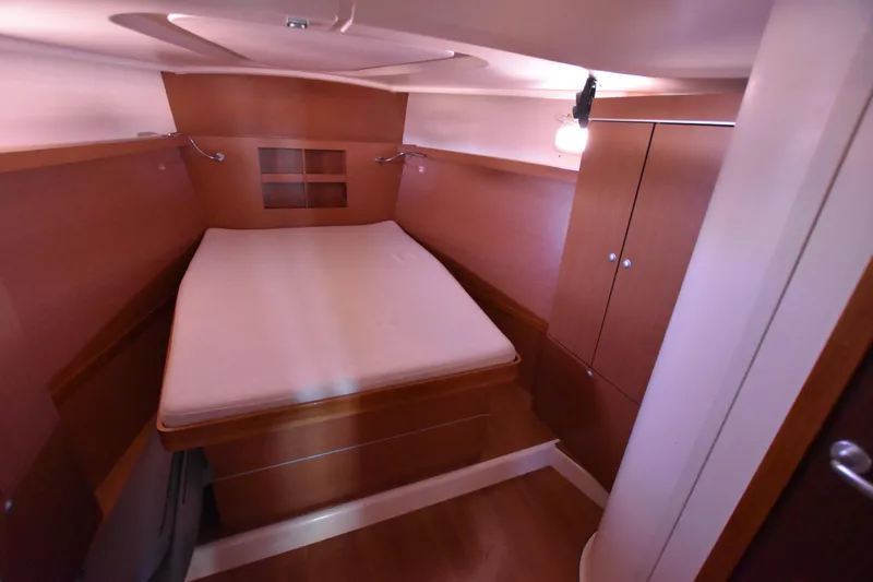 Starla Yacht Photos Pics Spacious cabin interior of 2012 Hanse 445 sailboat with wooden furnishings and bed.
