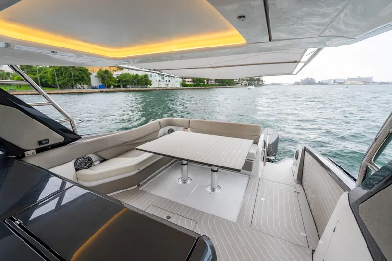 Azul Yacht Photos Pics Luxurious 2021 Azimut Verve 47 yacht deck with seating and table, overlooking serene waters.