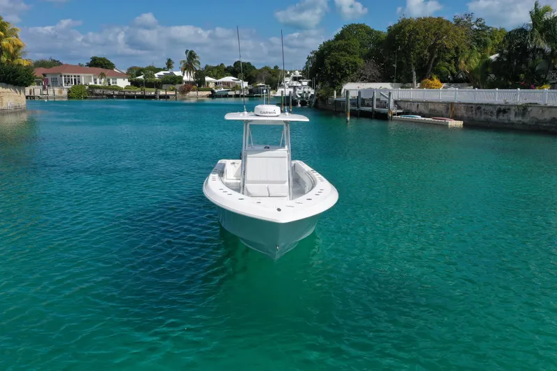 No Name Yacht Photos Pics 2023 Contender 32 ST boat on clear turquoise water, surrounded by lush greenery.