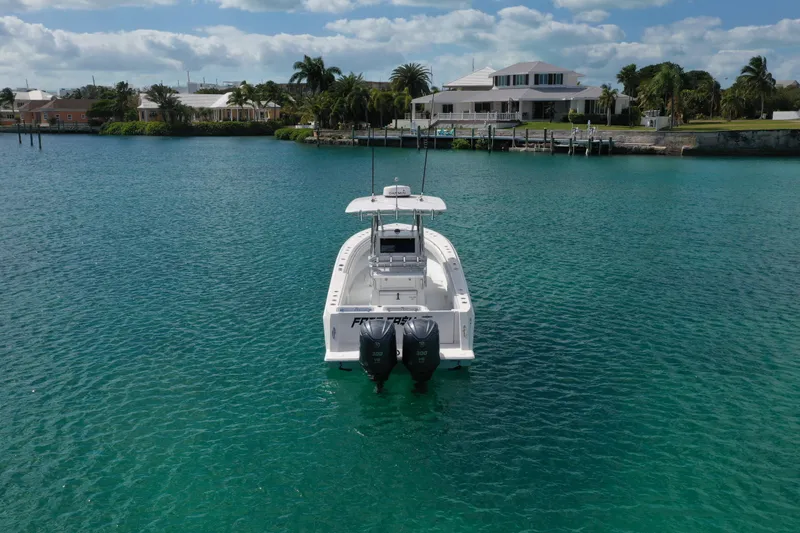 No Name Yacht Photos Pics 2023 Contender 32 ST boat on clear blue water near waterfront homes.