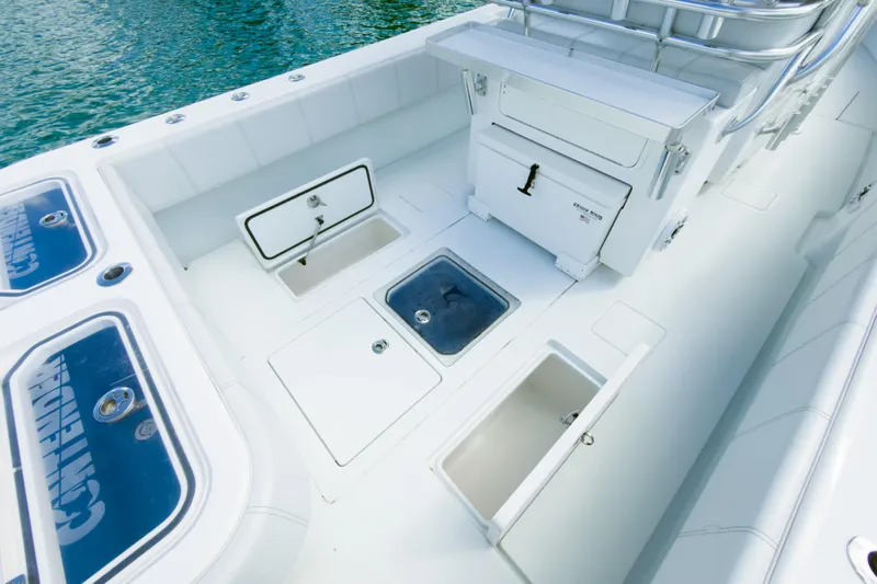 No Name Yacht Photos Pics 2023 Contender 32 ST boat deck with storage compartments and seating, on clear water.