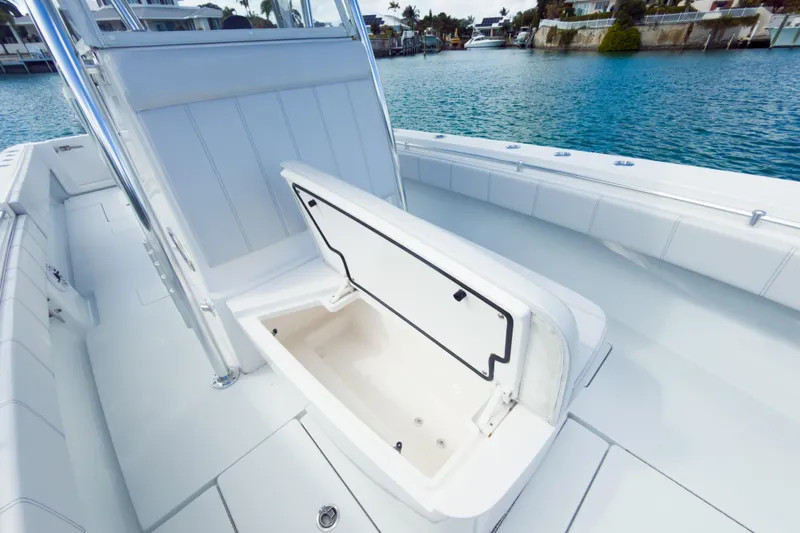 No Name Yacht Photos Pics 2023 Contender 32 ST boat with open storage compartment, docked by clear blue water.