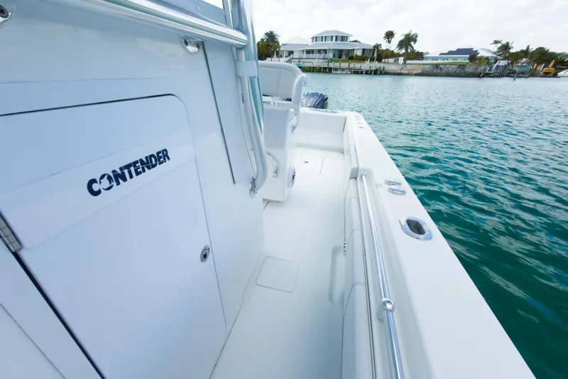 No Name Yacht Photos Pics 2023 Contender 32 ST boat docked by waterfront homes, showcasing sleek design.