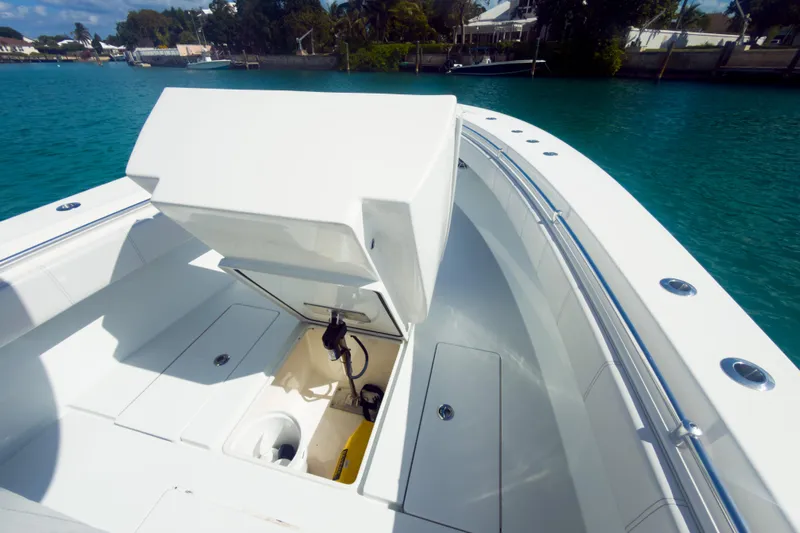 No Name Yacht Photos Pics 2023 Contender 32 ST boat with open storage compartment, docked in clear blue water.