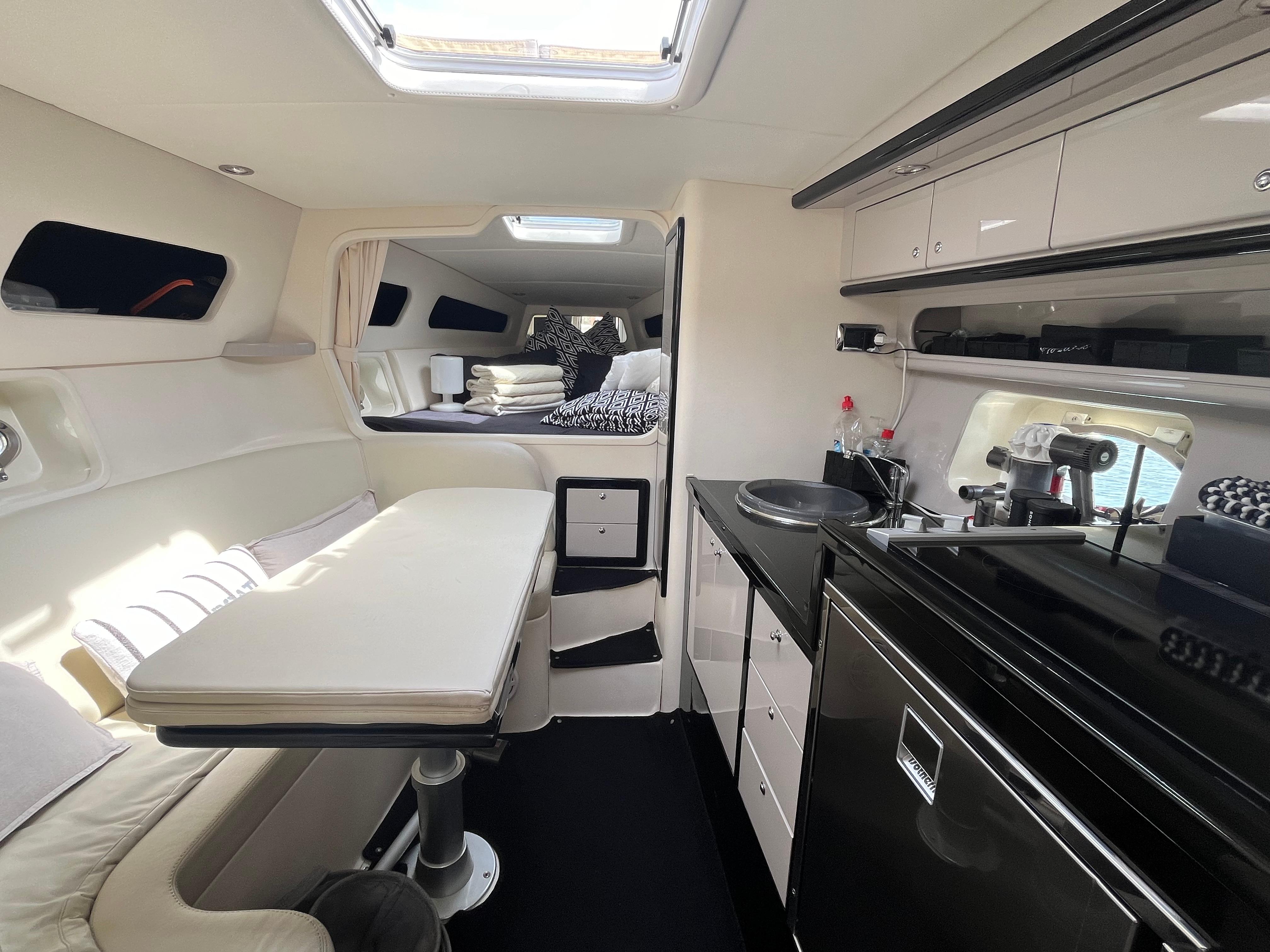 Luxurious 2007 Performance 1107 yacht interior with modern kitchen and cozy seating area.