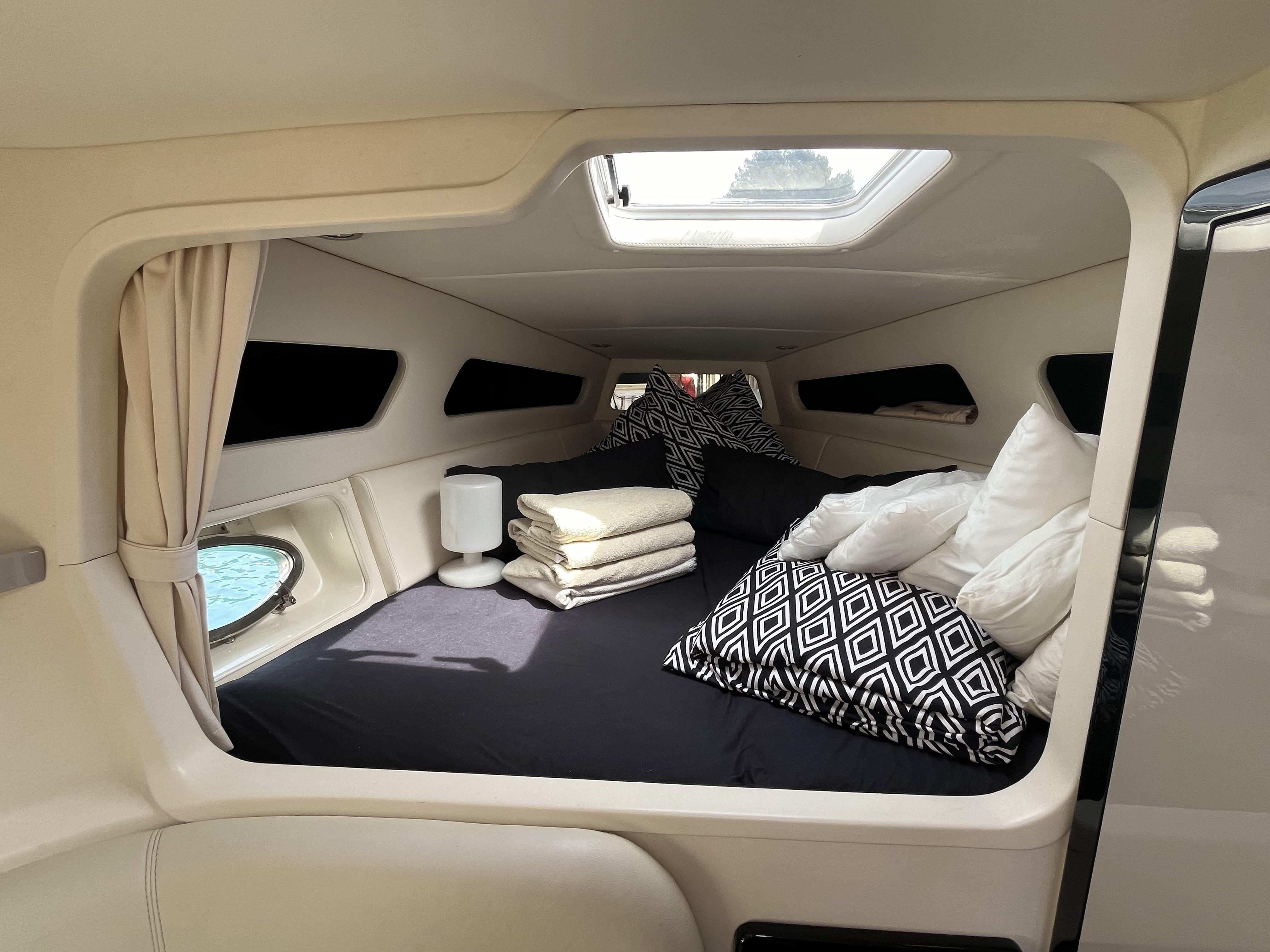 Luxurious cabin interior of a 2007 Performance 1107 boat with plush bedding and modern decor.