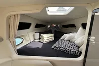 Luxurious cabin interior of a 2007 Performance 1107 boat with plush bedding and modern decor.