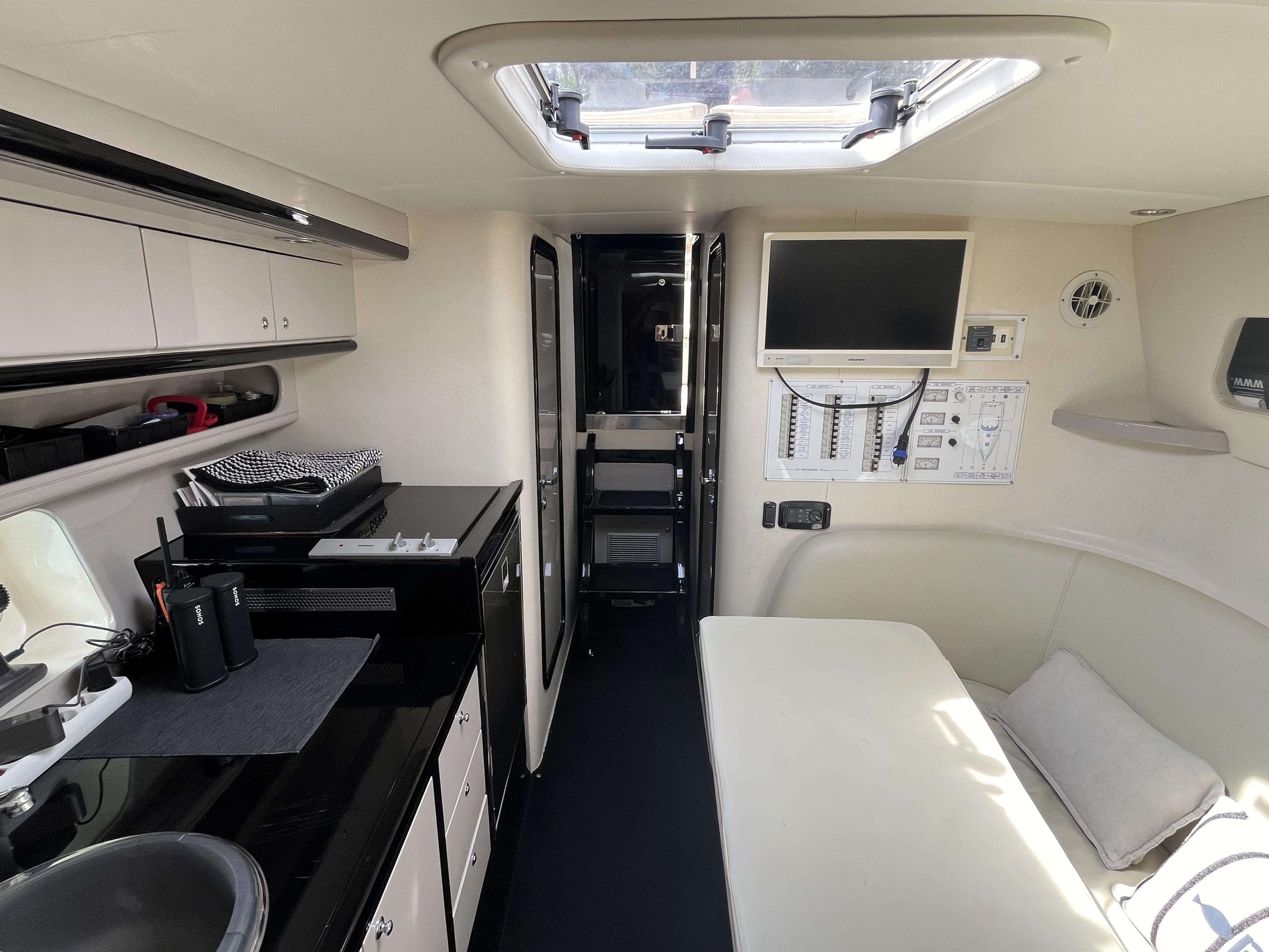 Interior of a 2007 Performance 1107 boat, featuring a compact kitchen and seating area.