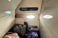 Compact cabin storage area with bags and shoes, featuring a small window. Performance 1107, 2007 model.
