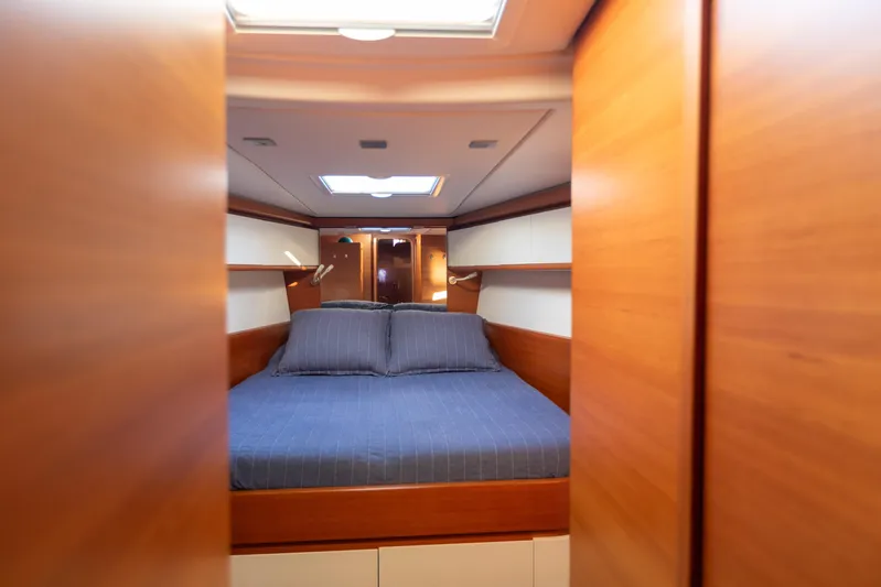  Yacht Photos Pics Luxurious cabin interior of 2014 Italia Yachts 15.98 with wooden finish and cozy bedding.