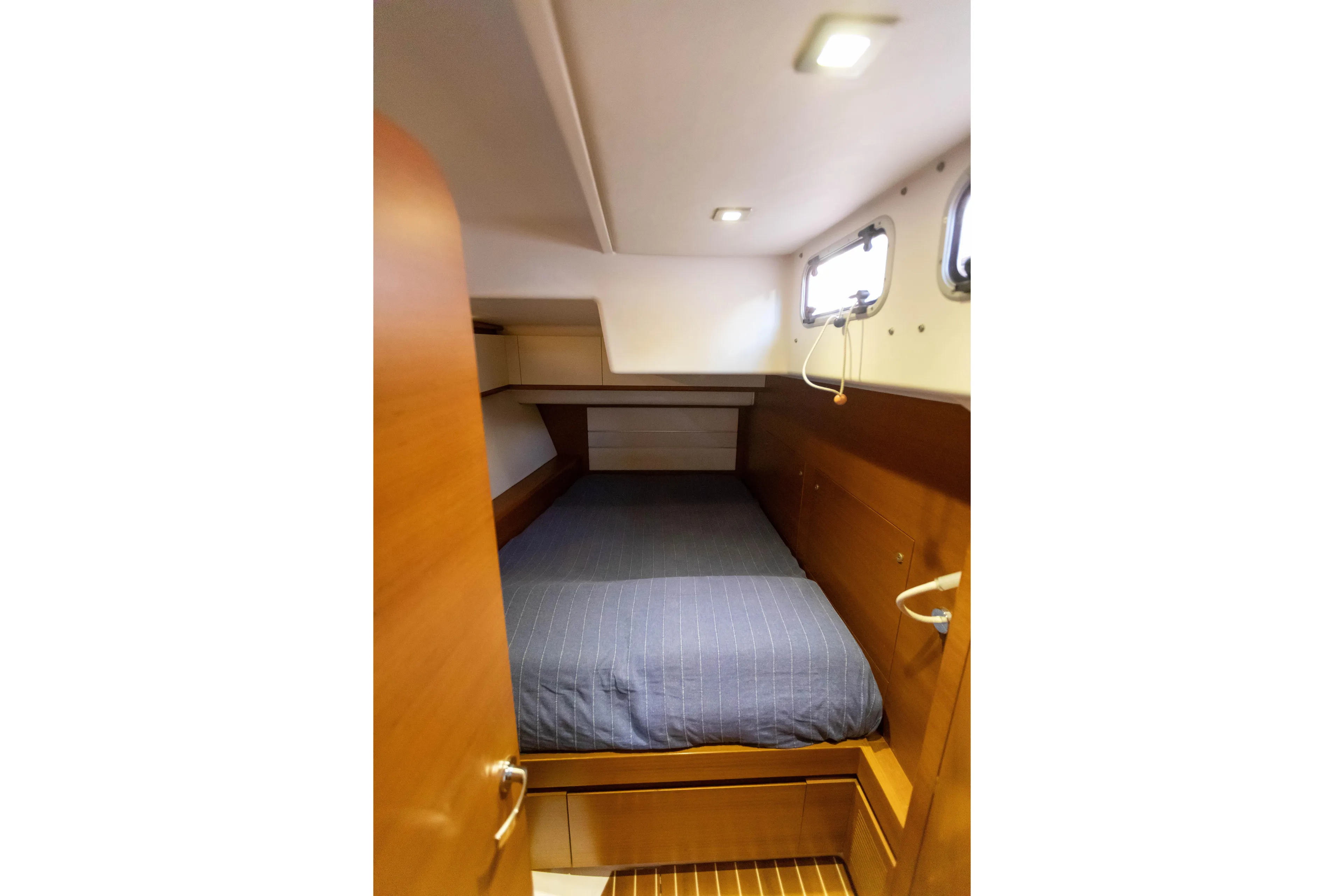 Yacht Photos Pics Cozy cabin interior of 2014 Italia Yachts 15.98 with wooden finish and bedding.