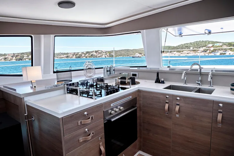  Yacht Photos Pics Modern kitchen interior on Bali 4.4 yacht, 2025 model, with ocean view through large windows.