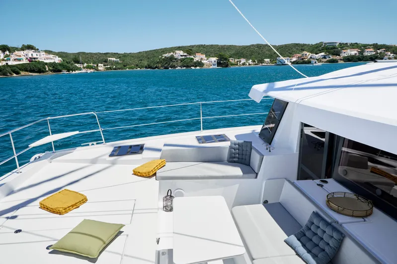  Yacht Photos Pics Luxurious Bali 4.4 yacht deck with cushions, overlooking serene blue waters and coastal homes.