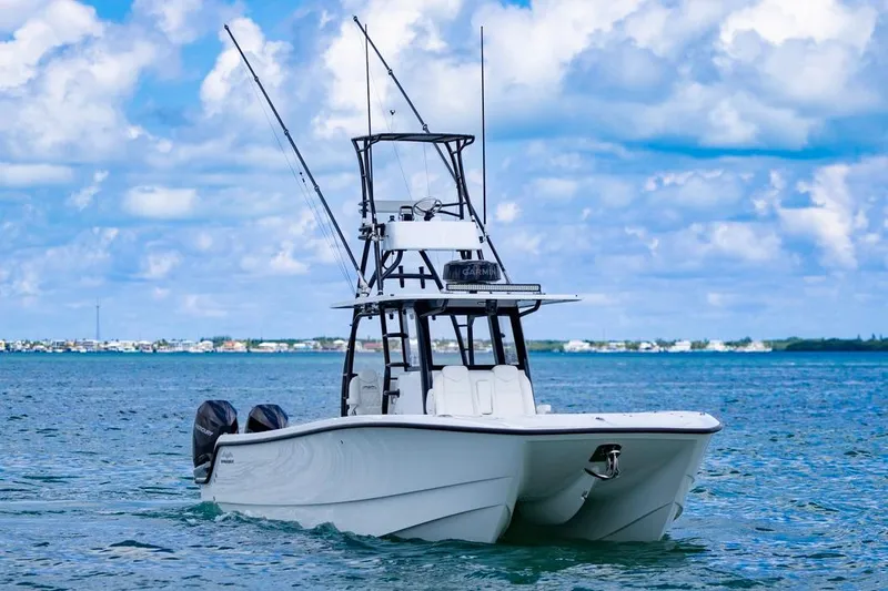  Yacht Photos Pics 2026 Invincible 36 Catamaran on open water, clear sky, dual engines visible.
