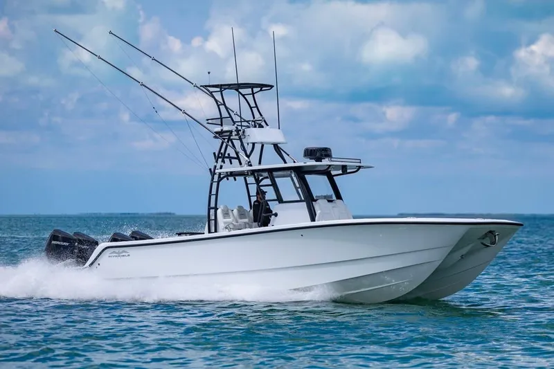  Yacht Photos Pics 2026 Invincible 36 Catamaran cruising on open water under a clear sky.