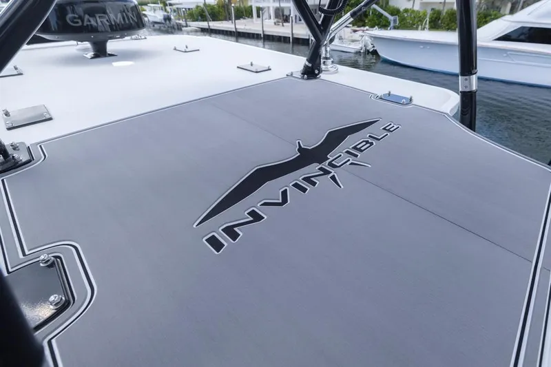  Yacht Photos Pics 2026 Invincible 36 Catamaran deck with logo, docked near other boats.