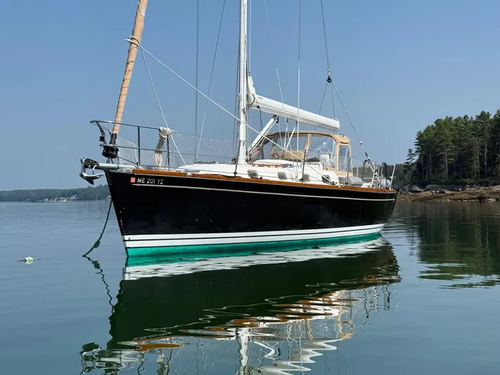 Dawn Treader Yacht Photos Pics Tartan 3700 Keel/Centerboard sailboat from 2005 on calm water, with forested shoreline.